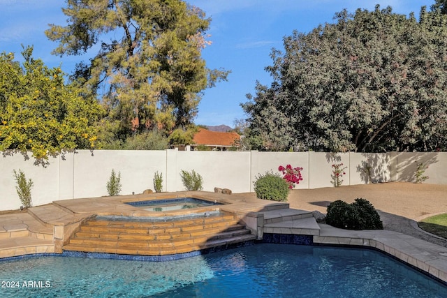 view of swimming pool with an in ground hot tub and a mountain view