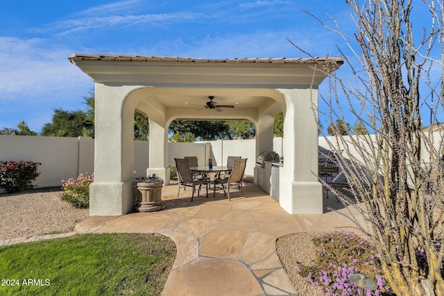 view of patio / terrace with grilling area, ceiling fan, and an outdoor kitchen