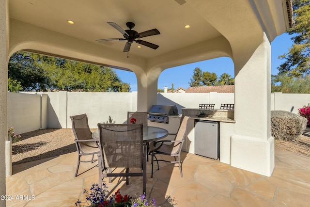 view of patio with an outdoor kitchen, ceiling fan, and area for grilling