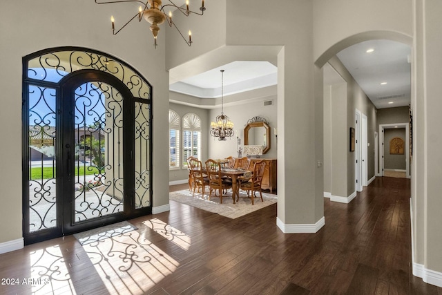 foyer featuring an inviting chandelier, dark wood-type flooring, a high ceiling, and french doors