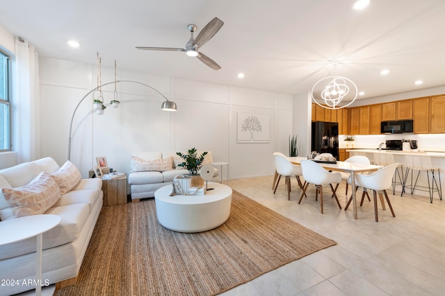 living room with ceiling fan with notable chandelier