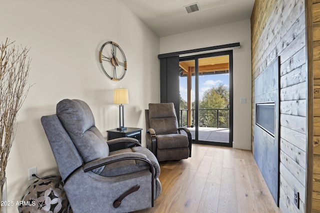 living area with light wood-style flooring and visible vents