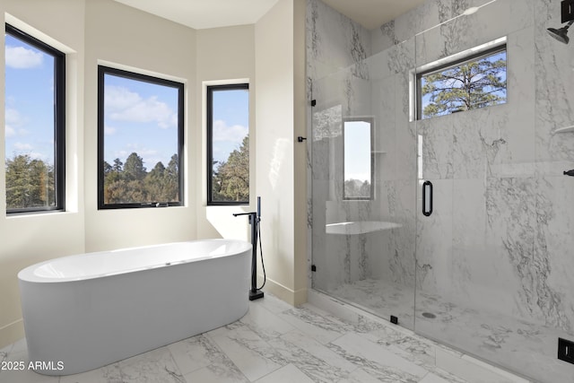 bathroom featuring marble finish floor, a freestanding bath, and a marble finish shower