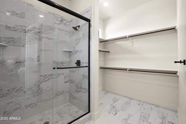 full bath with recessed lighting, baseboards, marble finish floor, a marble finish shower, and a walk in closet