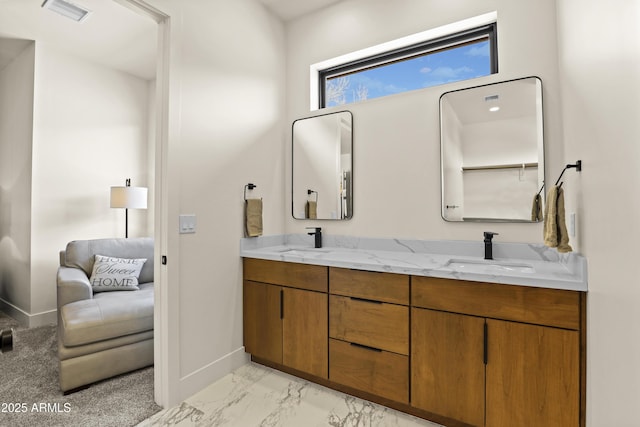 bathroom with marble finish floor, double vanity, visible vents, a sink, and baseboards