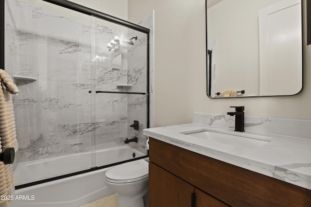 bathroom featuring toilet, bath / shower combo with glass door, and vanity