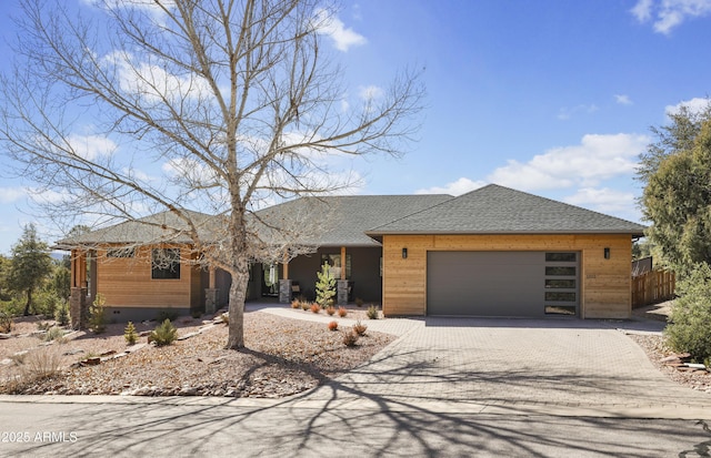 view of front of property featuring an attached garage, crawl space, decorative driveway, and roof with shingles