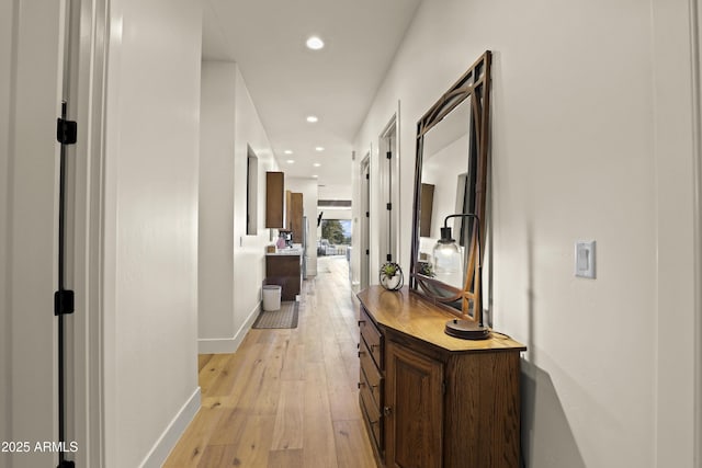 hallway featuring light wood-style floors, recessed lighting, and baseboards