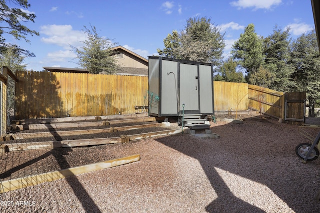 view of shed with entry steps and a fenced backyard