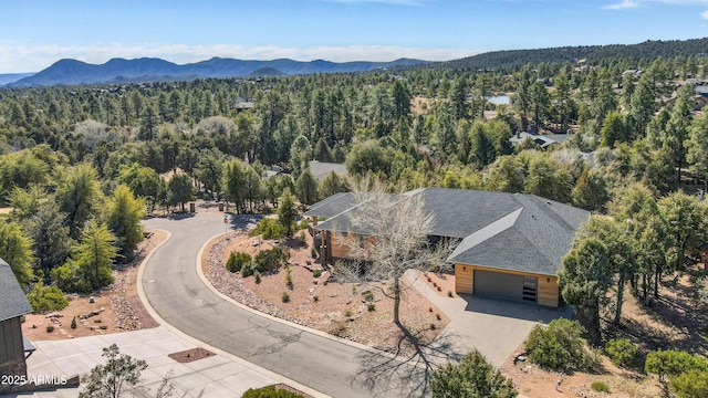 birds eye view of property featuring a mountain view and a wooded view