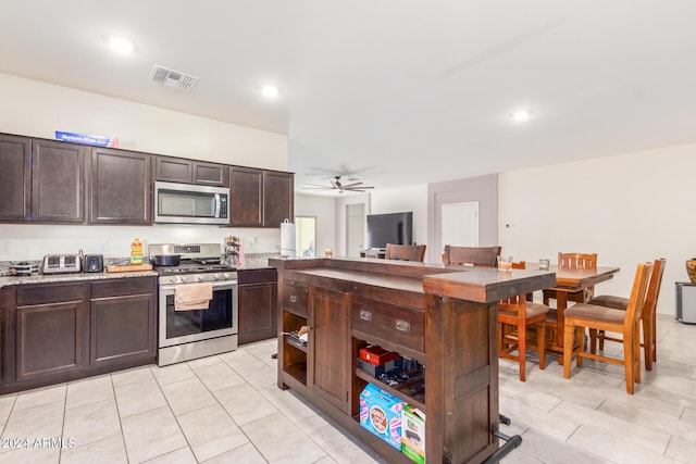 kitchen with stainless steel appliances, light countertops, visible vents, and dark brown cabinets