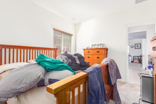 bedroom featuring visible vents and light colored carpet