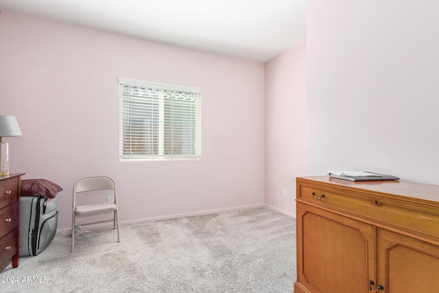 sitting room featuring light carpet and baseboards