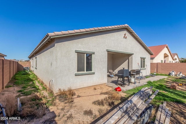 back of property featuring a patio area, a fenced backyard, a tiled roof, and stucco siding