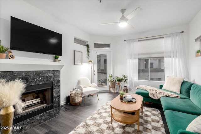 living room with ceiling fan, dark wood-type flooring, and a fireplace