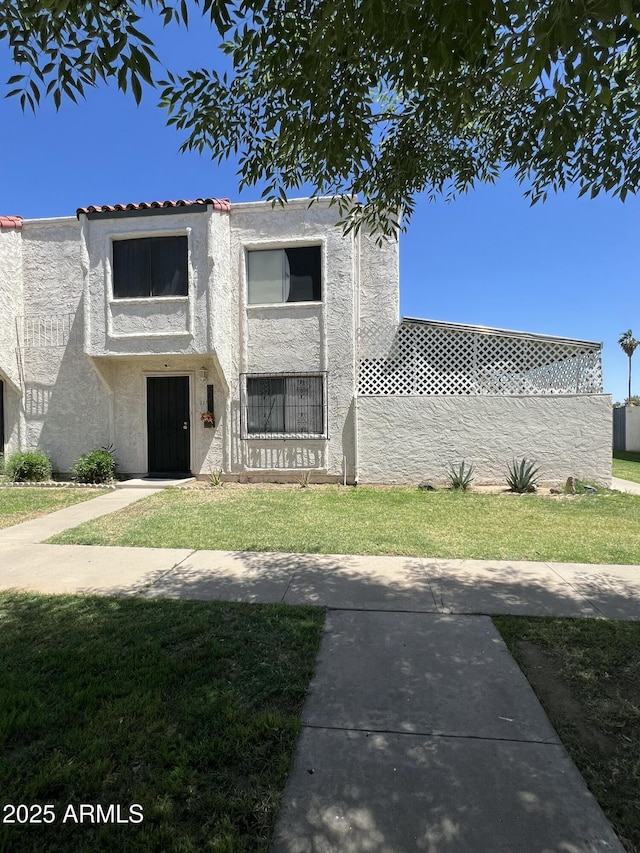 property under construction featuring stucco siding, a front yard, and a tile roof