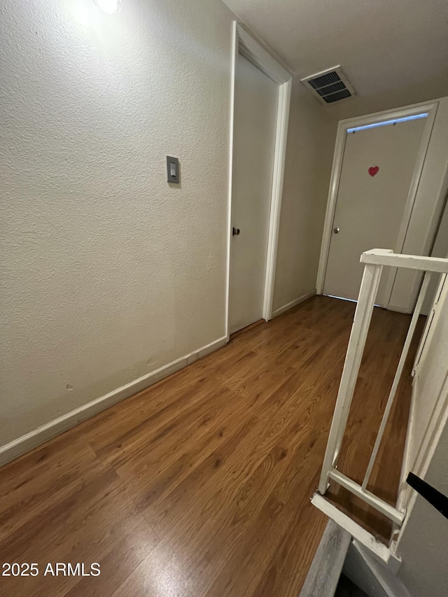 empty room featuring wood finished floors and baseboards