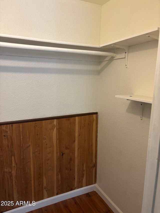 spacious closet with dark wood-style floors