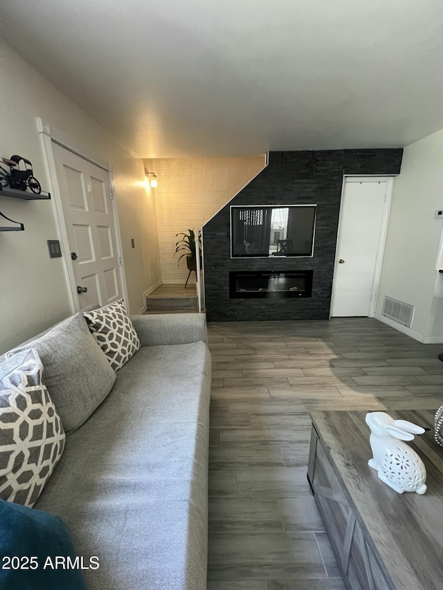 living room with a glass covered fireplace and wood finished floors