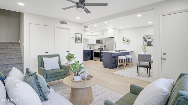 living room with ceiling fan and light wood-type flooring