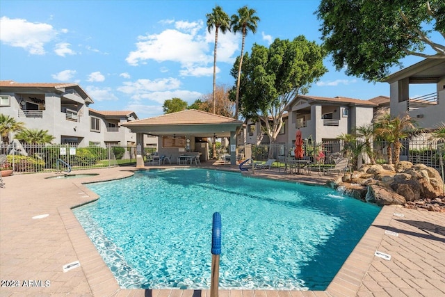 view of swimming pool featuring pool water feature and a patio area