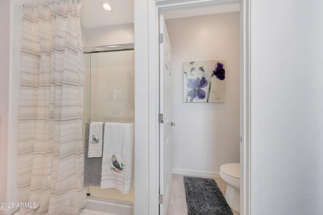 bathroom featuring a shower, tile patterned floors, and toilet