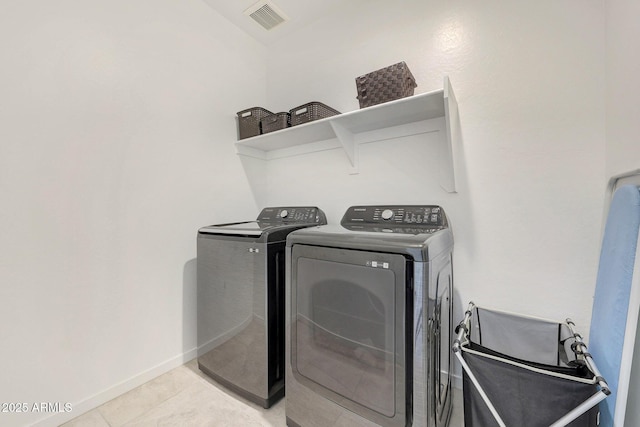 laundry area with light tile patterned flooring and separate washer and dryer