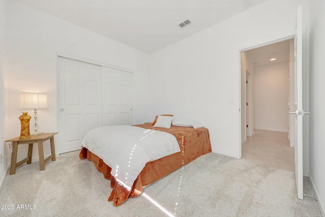 bedroom featuring light colored carpet and a closet