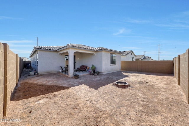 back of property featuring a patio and a fire pit