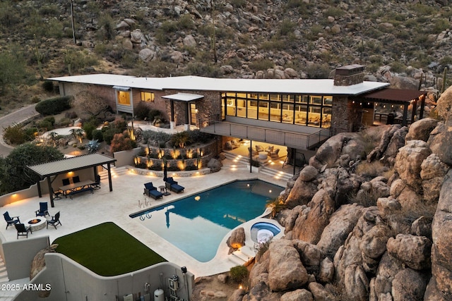 outdoor pool featuring a patio area, fence, a fire pit, and an in ground hot tub