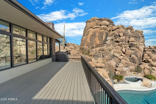 wooden terrace featuring a jacuzzi and a fenced in pool