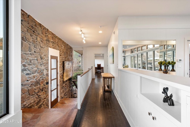 hall with hardwood / wood-style flooring and an upstairs landing