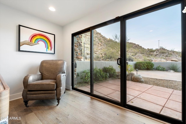 doorway with baseboards, wood finished floors, and recessed lighting