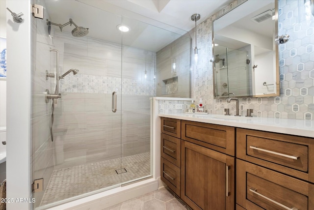 bathroom with backsplash, a shower stall, vanity, and tile patterned floors