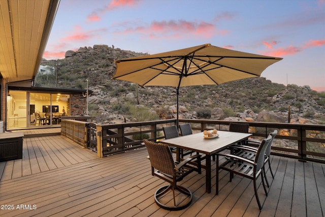 deck at dusk featuring outdoor dining space