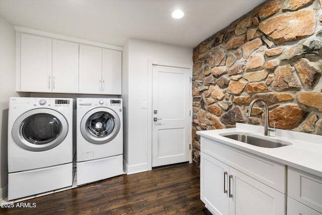 clothes washing area featuring cabinet space, dark wood-style flooring, washer and dryer, a sink, and recessed lighting