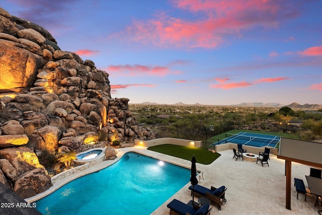 outdoor pool featuring a patio area, fence, a fire pit, and a mountain view