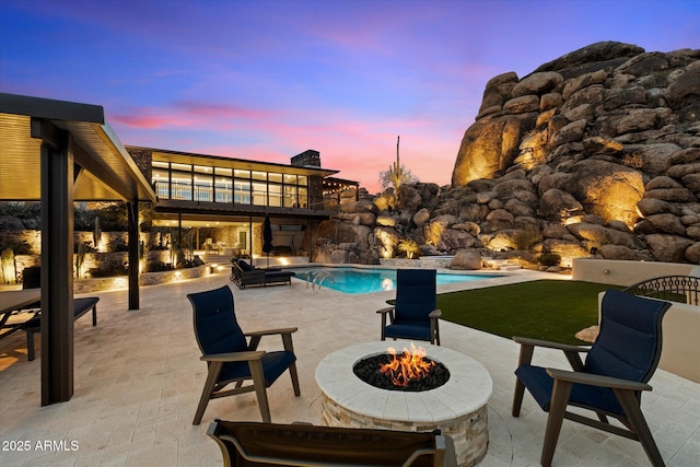 outdoor pool featuring a patio area and a fire pit