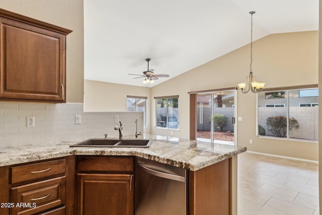 kitchen with lofted ceiling, sink, backsplash, stainless steel dishwasher, and light stone countertops