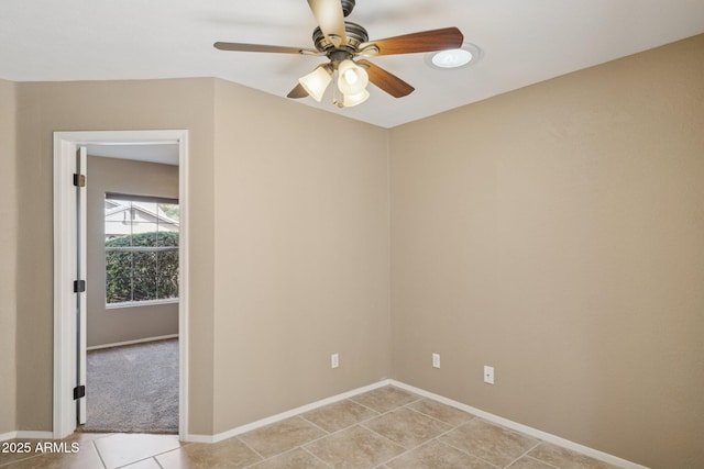 tiled spare room featuring ceiling fan