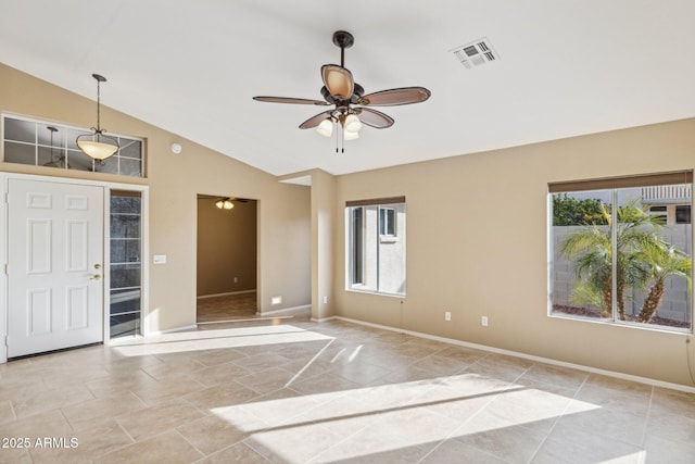 tiled empty room with vaulted ceiling, plenty of natural light, and ceiling fan