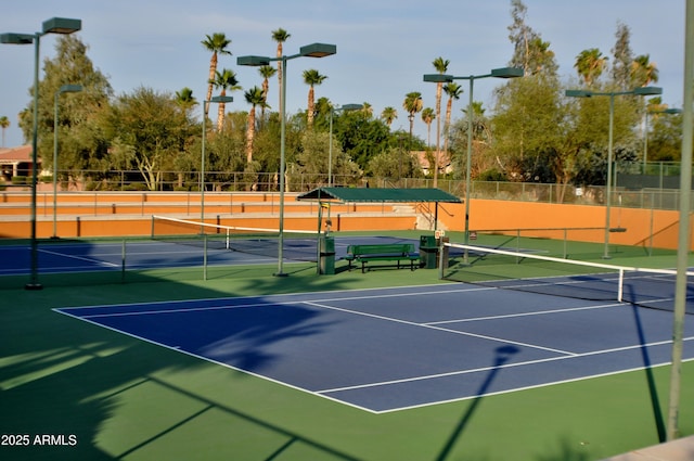 view of tennis court featuring basketball hoop