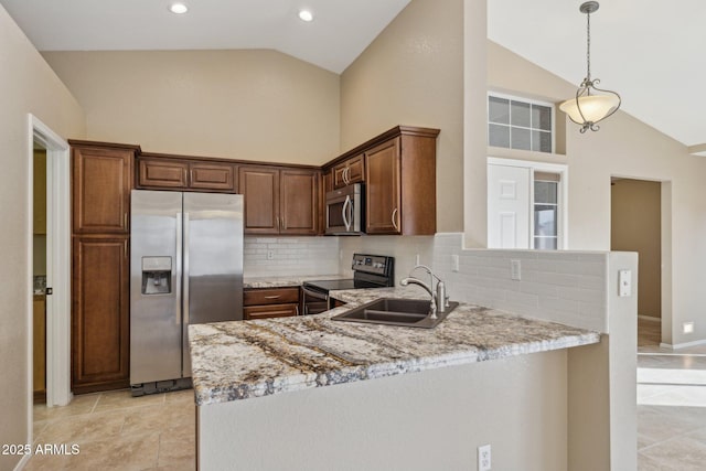 kitchen with stainless steel appliances, light stone countertops, sink, and kitchen peninsula