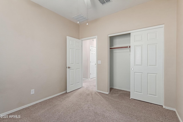 unfurnished bedroom featuring light carpet and a closet