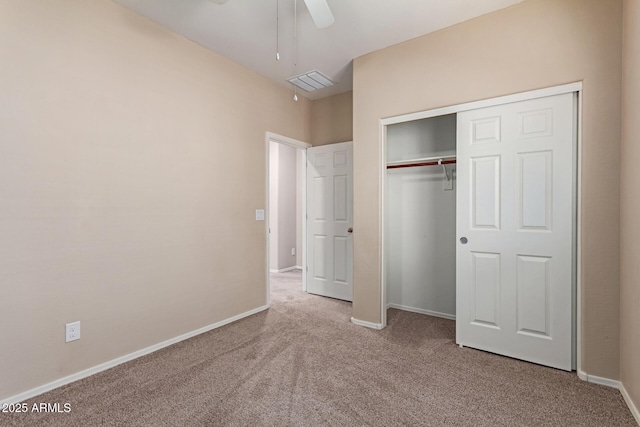 unfurnished bedroom with light colored carpet, ceiling fan, and a closet