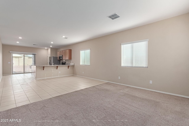 unfurnished living room with a wealth of natural light and light colored carpet