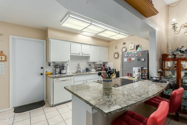 kitchen with sink, stainless steel refrigerator, dishwasher, black electric stovetop, and white cabinets