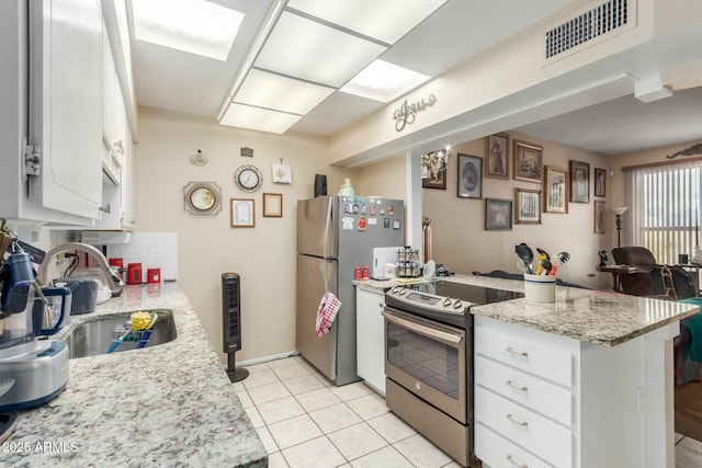 kitchen with sink, stainless steel appliances, light stone counters, tasteful backsplash, and white cabinets