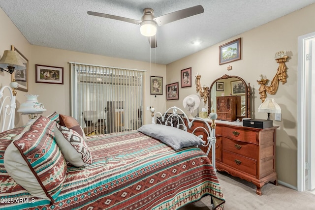 carpeted bedroom with ceiling fan, access to exterior, and a textured ceiling