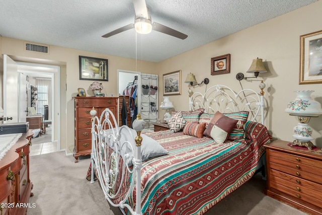 carpeted bedroom with ceiling fan and a textured ceiling